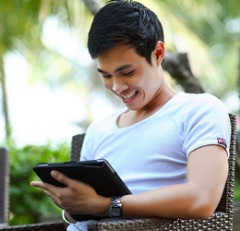 Young man looking at a tablet outside.